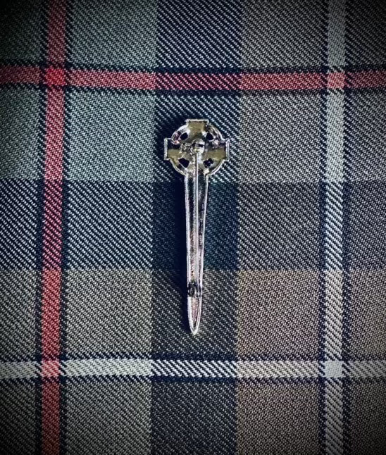 The Backside of a Kilt Pin/Cap Badge. Celtic Design pin brooch with weathered mckenzie background